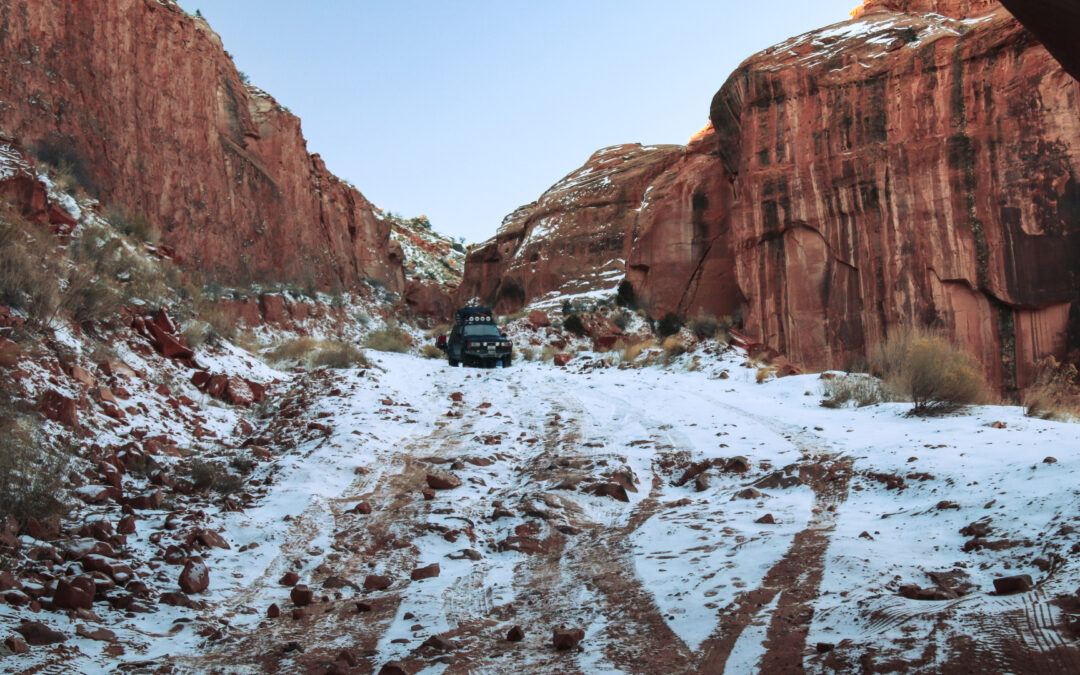 An overland truck at the top of a very icy and steep trail